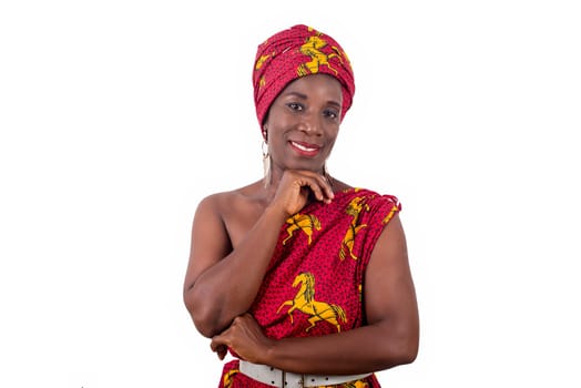 young woman standing in loincloth in a studio with hand under chin looking at camera smiling.