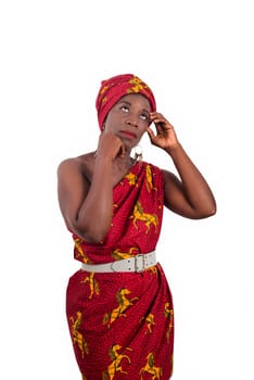 fashionable woman in red traditional dress hand on head looks away pensive
