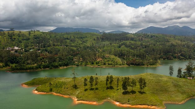 Hills with tea plantations around the lake in the mountains. Maskeliya, Castlereigh, Sri Lanka.