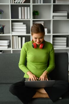 Beautiful Asian woman freelancer sitting on couch and using laptop. Communication, people, technology concept.