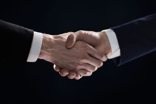 Handshake - Hand on a black background. success concept