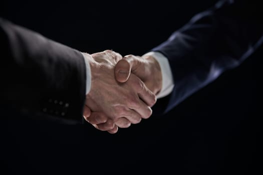 Handshake - Hand on a black background. success concept