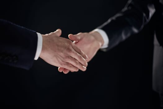 Handshake - Hand on a black background. success concept