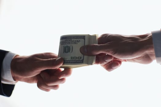 Man offering batch of hundred dollar bills. Hands close up.