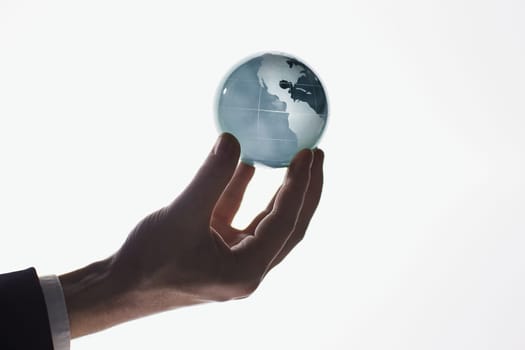 Businessman holding glass globe isolated on white background