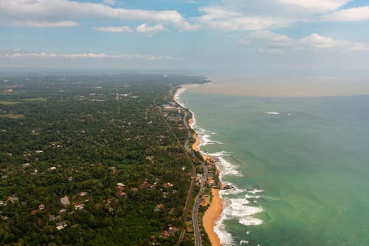 Beautiful beach, palm trees by turquoise water view from above. Hikkaduwa, Sri Lanka.