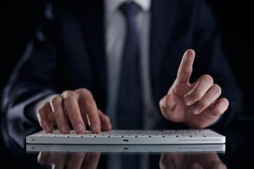 man in suit typing on the keyboard with care