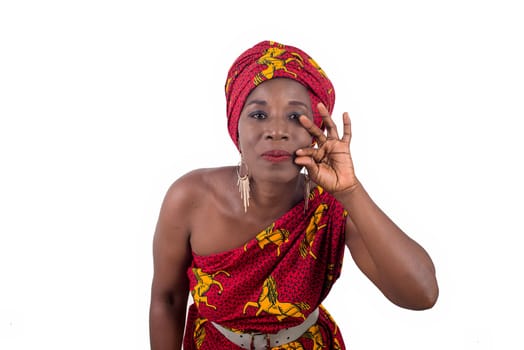 Beautiful african woman wearing traditional clothes, looking at the camera and making a hand gesture isolated on white background