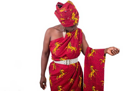 fashionable woman in red traditional dress, looks and presents an African stuff