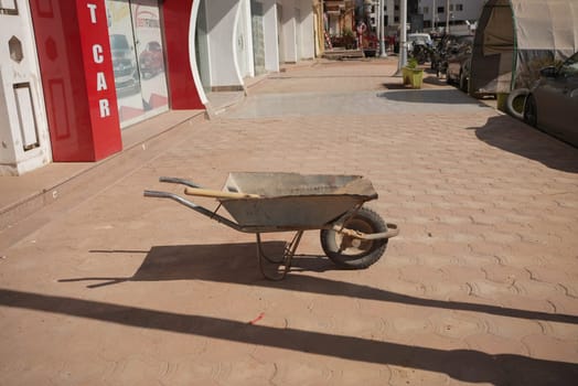 Wheelbarrow left abandoned in the middle of a city street. High quality photo