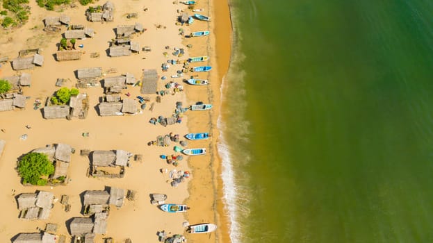 Aerial drone of Wooden houses in a fishing village on the ocean coastline. Sri Lanka.