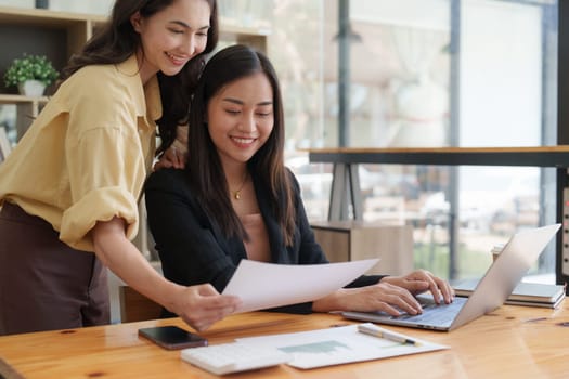 Asian Business team makes analysis and research financial report at office, analyzes profits. Accountant checks status of financial.