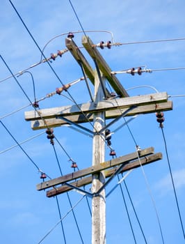 Electric pole and wires, wood electricty pole on blue sky background