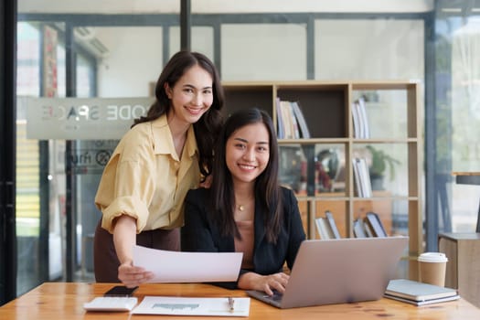 Asian Business team makes analysis and research financial report at office, analyzes profits. Accountant checks status of financial.