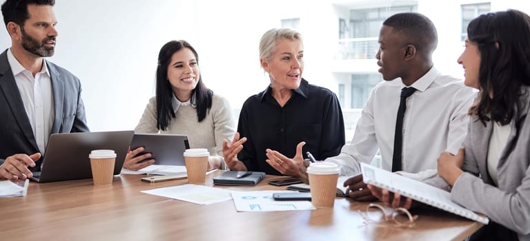 Business people, meeting and professional team talking in a corporate office for brainstorming. Diversity men and women at a table for planning, discussion and strategy with technology and ideas.