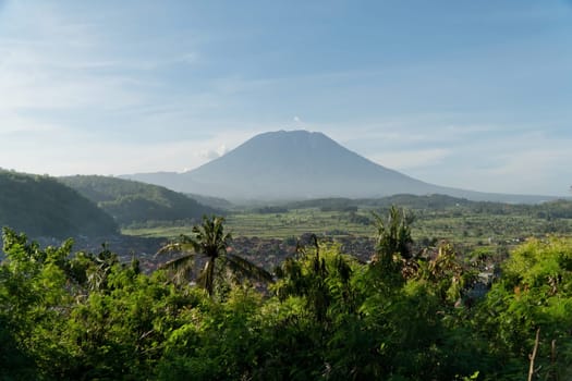 Aerial view Town near volcano Agung, rice terrace, farmlands, village, fields with crops, agricultural land of farmers. Bali, Indonesia