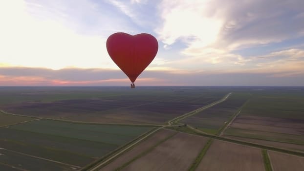 Hot air balloon shape of a heart in the blue sky. Aerostat, Airship. Red balloon.