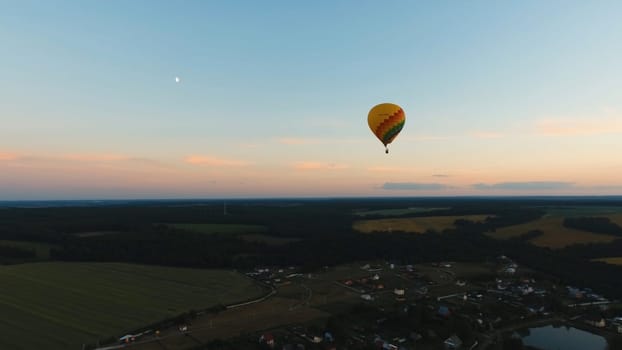 Aerial view Hot air balloon in the sky over a field in the countryside in the beautiful sky and sunset. Balloon silhouette with sunrise, Aerostat fly in the countryside.