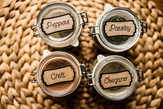 Set of different spicies and peppers in glass jars at the kitchen.