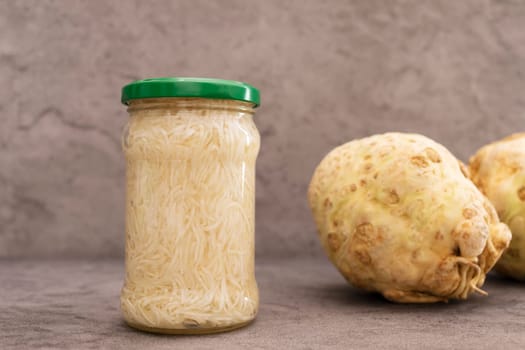 Preserved Shredded, Pickled Celery Root Salad In Glass Jar With Screw Metal Cap On Shelf. Celery Crops, Tuber Beside. Apium Graveolens, Harvesting Culinary. Vitamins C, K, A, E,PP, B Horizontal Plane.