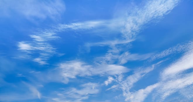 Bright blue sky with fine cirrus clouds, abstract nature background.