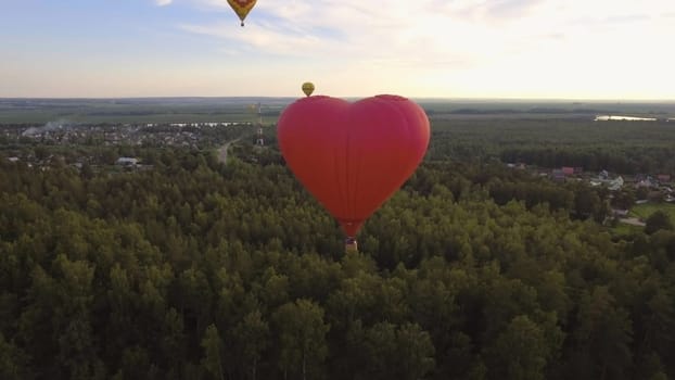 Hot air balloon shape of a heart in the blue sky. Aerostat, Airship. Red balloon.