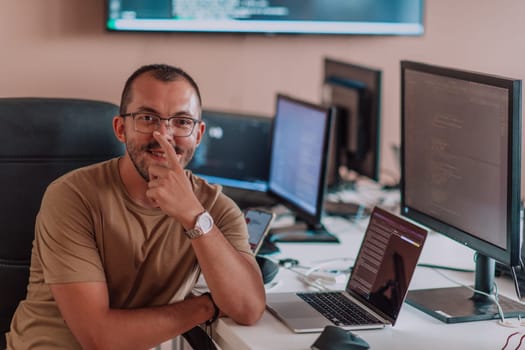 A programmer diligently testing smartphone applications while sitting in their office. High quality photo