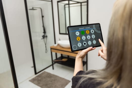 Female hands holding digital tablet with smart home app.