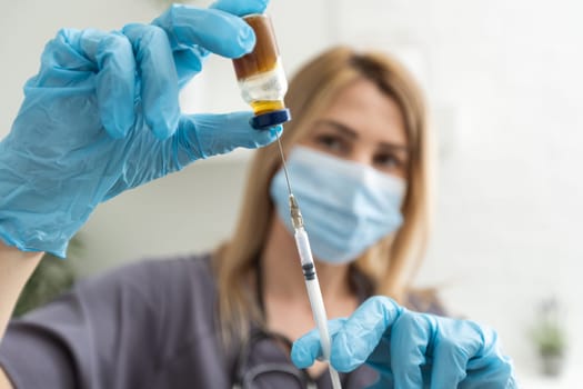 COVID-19 vaccine in researcher hands, female doctor's holds syringe and bottle with vaccine for coronavirus cure. Concept of corona virus treatment, injection, shot and clinical trial during pandemic