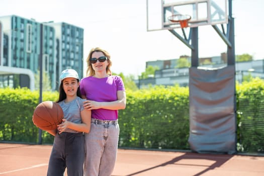 Mother and daughter playing basketball.