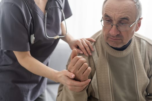 Kind female doctor embracing encouraging senior male patient in hospital. Happy healthy older man and his physician enjoying talking at nursing home. Elderly medical health care concept