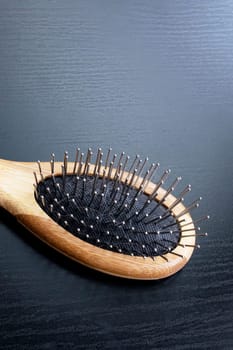 Wooden comb on a black background close up