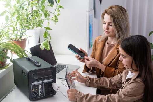 mother and daughter use a portable charging station.