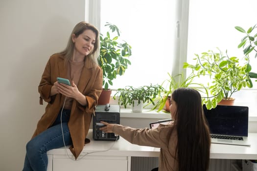 mother and daughter use portable charger.