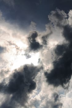 Dark stormy sky with clouds and sunlight, background