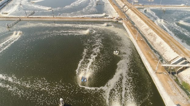 shrimp farm, prawn farming with with aerator pump oxygenation water near ocean. aerial view fish farm with ponds growing fish and shrimp and other seafood. Fish hatchery pond aerial view aquaculture business exported international market. java, indonesia