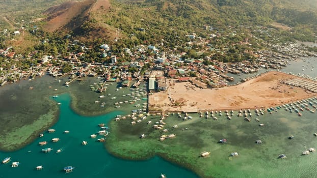 sea port, pier, cityscape Coron town with boats on Busuanga island, Philippines, Palawan. Coron city with slums and poor district. Seascape with mountains.