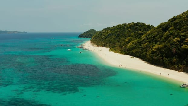 Sandy tropical beach with tourists and blue clear sea. Summer and travel vacation concept. Boracay, Philippines. Seascape with beach on tropical island. Puka shell beach
