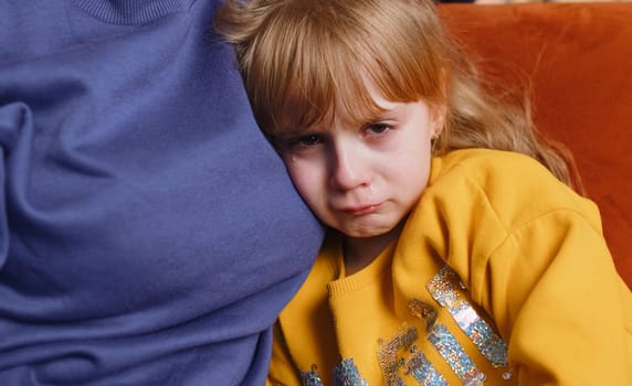 Offended sad girl kid is crying and lying on mother at home. Violence against children in family. Quarrel, bullying at school. Child toddler abuse. Mom hugs, embrace, takes pity on her daughter