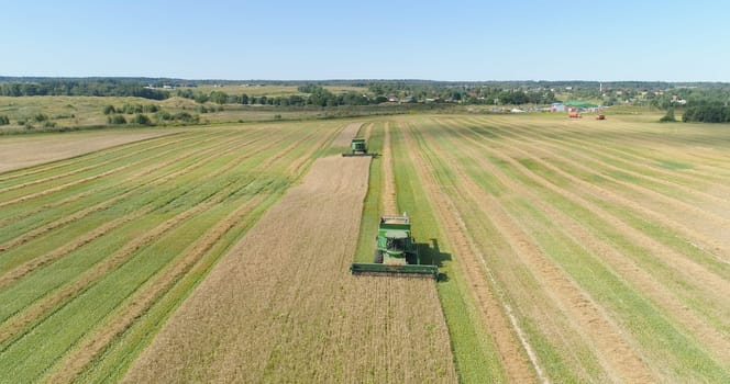 Combine harvester at work harvesting field wheat. Aerial view Combine harvester mows ripe spikelets, barley, rye. Combine harvester harvest ripe wheat on a farm.