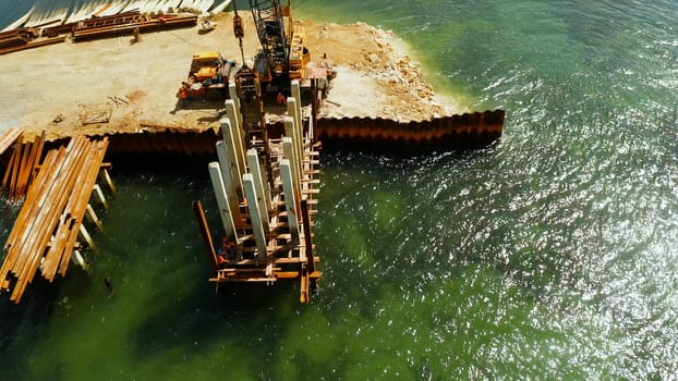 Pile driving machine in construction site.The bridge under construction across the bay and construction equipment with workers on the bridge. Siargao, Philippines.