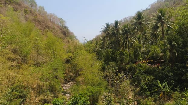 aerial view slopes mountains covered with forest and vegetation against blue sky. mountain hilly landscape in asia. tropical landscape