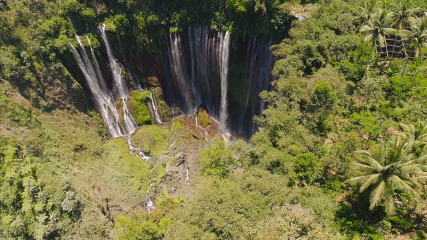 beautiful waterfall Coban Sewu in tropical forest, Java Indonesia. aerial view tumpak sewu waterfall in rainforest