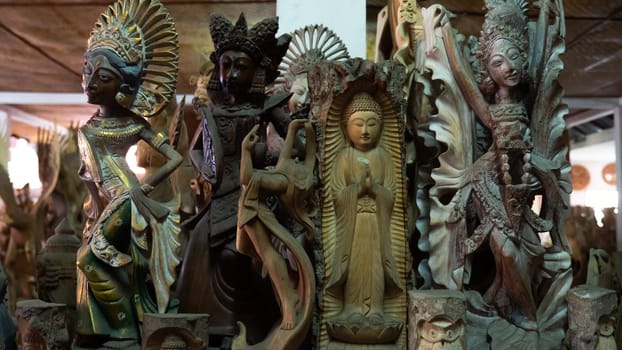 Hindu and Buddhist wooden carving. souvenir shop selling souvenirs and handicrafts of Bali at famous Ubud Market, Indonesia