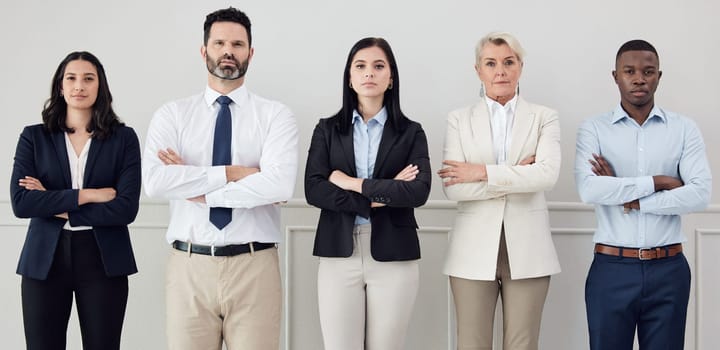 Portrait, professional and arms crossed with a business team standing together in a corporate office. Collaboration, teamwork and management with a group of serious people looking confident at work.