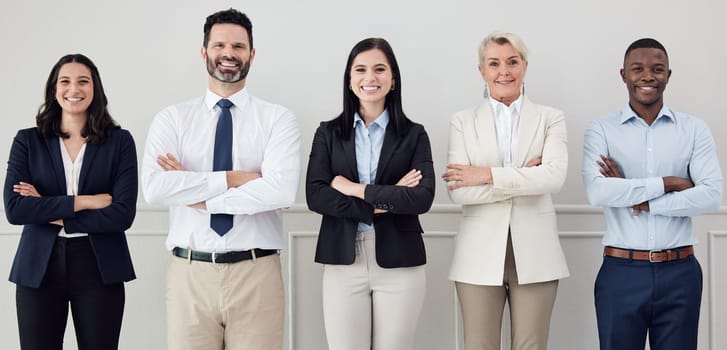 Portrait, collaboration and arms crossed with a diverse leadership team standing in their professional office. Business, teamwork and management with a group of colleagues looking confident at work.