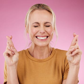 Woman, fingers crossed and hope in studio, pink background and smile face. Female model wish for luck with hands of bonus, promotion and winning giveaway for emoji sign, competition prize and lottery.
