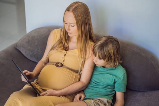 pregnant mom and son look at the tablet. Reading a book or watching a cartoon or making a video call. Look at the photo from the ultrasound.