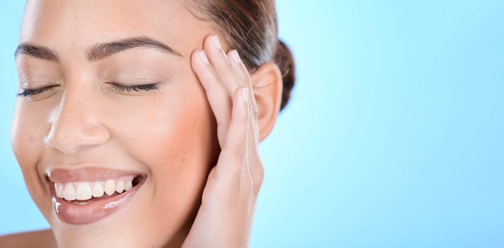 Face, beauty and mockup with a model black woman in studio on a blue background for natural skincare. Happy, smile and cosmetics with an attractive young female posing to promote advertising space.