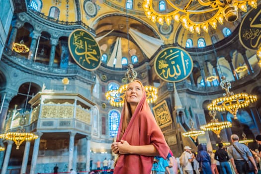 INSCRIPTION - denoting the names of Allah, the Prophet Muhammad, as well as the first 4 caliphs Woman tourist enjoying Hagia Sofia, Ayasofya interior in Istanbul, Turkey, Byzantine architecture, city landmark and architectural world wonder. Turkiye.